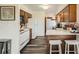 Bright kitchen with wooden cabinets, white appliances, modern countertops and bar stool seating at 28669 Mountain View Rd, Conifer, CO 80433