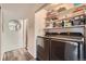 Laundry room with modern washer and dryer units, storage shelves and a mirror at 28669 Mountain View Rd, Conifer, CO 80433