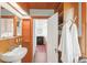 Cozy bathroom with wood panels, a sink, cabinets, and a peek into the neighboring kitchen area at 2845 Quitman St, Denver, CO 80212