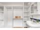 Bright closet with built-in shelving, hanging rods, and a vanity with a stylish sink and classic mirror at 2845 Quitman St, Denver, CO 80212