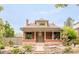 Inviting brick home featuring a covered front porch and mature landscaping at 2845 Quitman St, Denver, CO 80212