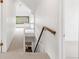 Bright hallway with stairs, a wooden handrail, and access to multiple rooms at 2845 Quitman St, Denver, CO 80212