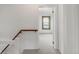 Hallway featuring white walls, wooden railing, and a glimpse into an adjacent bedroom at 2845 Quitman St, Denver, CO 80212