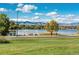 Scenic lake view showcasing lush greenery, distant mountains, and a bright, sunny sky with puffy clouds at 2845 Quitman St, Denver, CO 80212
