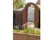 Charming brick archway and wrought iron gate surrounded by flower-filled planter, creating an inviting entrance at 2845 Quitman St, Denver, CO 80212