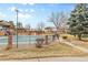 Outdoor pool with a black fence is surrounded by grass and several buildings at 9179 E Oxford Dr, Denver, CO 80237