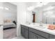 Bathroom featuring gray cabinets, dual sinks, and a view into the bedroom at 2455 Alpine St, Longmont, CO 80504