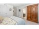 Bright bedroom with a large, decorative armoire and view into en suite bathroom at 2455 Alpine St, Longmont, CO 80504