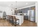 Modern kitchen with stainless steel appliances, white countertops, gray cabinets, and bar seating at 2455 Alpine St, Longmont, CO 80504