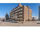 Brick apartment building featuring balconies and visible street parking in a vibrant urban setting at 4110 Hale Pkwy # 1E, Denver, CO 80220
