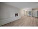 A spacious living room featuring a white brick fireplace, wood floors, and a mirrored wall at 4110 Hale Pkwy # 1E, Denver, CO 80220