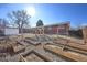 Empty raised garden beds in a sunny, fenced backyard with an adjacent small storage building at 1634 S Yukon Ct, Lakewood, CO 80232