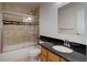 Bathroom featuring shower over tub with glass doors, sink with black countertop at 6055 W Warren, Lakewood, CO 80227