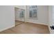 Bedroom featuring neutral walls, wood floors, a mirrored closet, and a window at 6055 W Warren, Lakewood, CO 80227