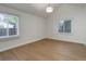 Bright bedroom featuring neutral walls, wood floors, and natural light from two large windows at 6055 W Warren, Lakewood, CO 80227