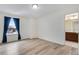 Bright bedroom with wood-look flooring, a large window with curtains, and an ensuite bathroom at 9976 Pitkin St, Commerce City, CO 80022