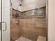 Elegant walk-in shower featuring travertine tile, a bench seat, and a glass enclosure in the ensuite bathroom at 5455 Landmark Pl # 1116, Greenwood Village, CO 80111