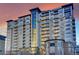 Luxury high-rise condominium featuring private balconies and stunning architectural design against an orange sunset at 5455 Landmark Pl # 1116, Greenwood Village, CO 80111