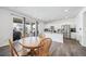 Dining area featuring a wood table, large window, and view of kitchen with white cabinetry at 9923 Truckee St, Commerce City, CO 80022