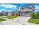 Two-story home with a two-car garage, gray siding and stone accents on the front porch columns at 9923 Truckee St, Commerce City, CO 80022