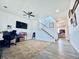Open-concept living room with carpeting, a ceiling fan, and view of staircase with white railings at 9923 Truckee St, Commerce City, CO 80022