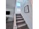 Carpeted staircase with white railings and a window that allows natural light to fill the space at 9923 Truckee St, Commerce City, CO 80022