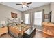 Cozy bedroom with a decorative wrought iron bed frame, ceiling fan, and natural light from two windows at 11865 Barrentine Loop, Parker, CO 80138