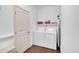 Functional laundry area equipped with a white washer and dryer, shelving, and an ironing board for convenience at 11865 Barrentine Loop, Parker, CO 80138
