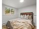 Cozy bedroom features a wood-paneled headboard, wainscoting, and a window view of the wooded exterior at 30938 Niakwa Rd, Evergreen, CO 80439