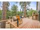 Spacious wooden deck with plenty of seating overlooking a lush forest landscape at 30938 Niakwa Rd, Evergreen, CO 80439