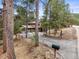 Secluded mountain home featuring a two-car garage, scenic views, and a charming driveway through the trees at 30938 Niakwa Rd, Evergreen, CO 80439