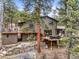 Two-story home features multiple decks and a stone wall at 30938 Niakwa Rd, Evergreen, CO 80439