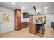 Modern kitchen showcasing custom cabinets, stone backsplash, a spacious island with bar seating, and herringbone floors at 30938 Niakwa Rd, Evergreen, CO 80439