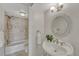 Well-lit bathroom with a pedestal sink, decorative mirror and tiled shower at 4800 E Hale Pkwy # 802N, Denver, CO 80220