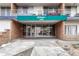 The building's entrance shows a brick facade, glass doors, and a green awning at 4800 E Hale Pkwy # 802N, Denver, CO 80220