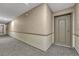 Carpeted hallway with neutral walls leading to a private door at 4800 E Hale Pkwy # 802N, Denver, CO 80220