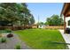 Spacious backyard featuring a lush lawn, wooden fence, mature trees, shed, and rock landscaping at 2635 Pierce St, Wheat Ridge, CO 80214