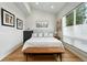 Bright bedroom featuring a large window, light grey walls, wood floors, and stylish artwork at 2635 Pierce St, Wheat Ridge, CO 80214