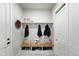 Mudroom with bench, storage, hooks, decorative tile floor, and a white shiplap accent wall at 2635 Pierce St, Wheat Ridge, CO 80214