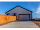 Attached garage with driveway and wooden fence at 2937 Pershing St, Strasburg, CO 80136