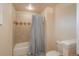 A bathroom with a classic white toilet and bathtub with blue and white striped shower curtain at 7750 S Glencoe Way, Centennial, CO 80122