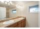 Bathroom features a double vanity, a large mirror, and a window providing natural light at 7750 S Glencoe Way, Centennial, CO 80122