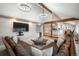 Open-concept living room with vaulted ceilings, wood beams, modern lighting, and plenty of seating at 7750 S Glencoe Way, Centennial, CO 80122