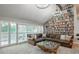 Vaulted living room with a floor-to-ceiling bookshelf, plush sofa, and a view of the lush backyard at 7750 S Glencoe Way, Centennial, CO 80122