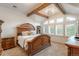 The main bedroom features beams, many windows, and an ornate, light-colored bed frame at 7750 S Glencoe Way, Centennial, CO 80122
