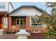 A charming brick home showcases a cozy front porch and well-maintained landscaping at 1463 Dahlia St # 2, Denver, CO 80220