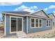 Exterior of home showcasing the blue siding and a sliding glass door at 13392 E 110Th Way, Commerce City, CO 80022