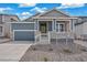 Inviting home featuring a covered front porch, two-car garage, and well-maintained landscaping at 13392 E 110Th Way, Commerce City, CO 80022