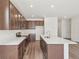 Well-equipped kitchen features a large center island, sleek brown cabinetry, and stainless steel appliances at 13392 E 110Th Way, Commerce City, CO 80022