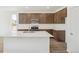 Bright kitchen featuring a spacious island, hardwood flooring, and elegant brown cabinets with stainless steel appliances at 13392 E 110Th Way, Commerce City, CO 80022